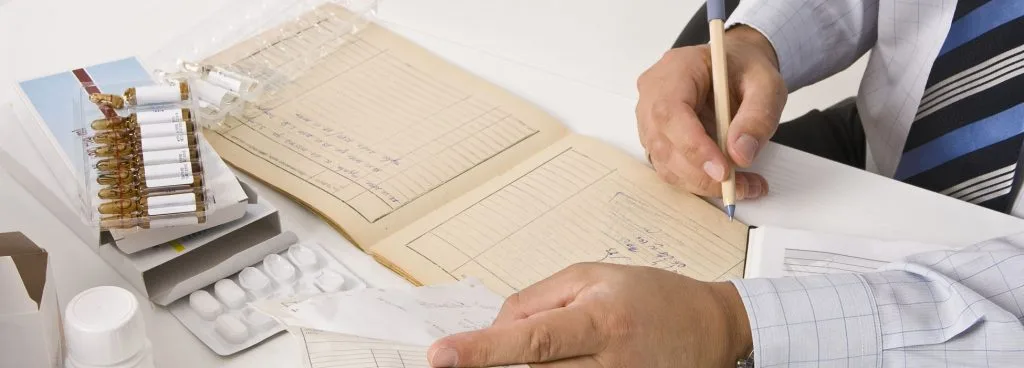 Researcher recording medical data, syringes, tablets visible, indicating clinical study on sarms and acne documentation.