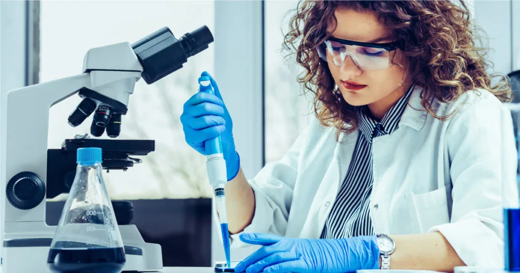 Laboratory scientist using pipette and microscope for mk677 research analysis.