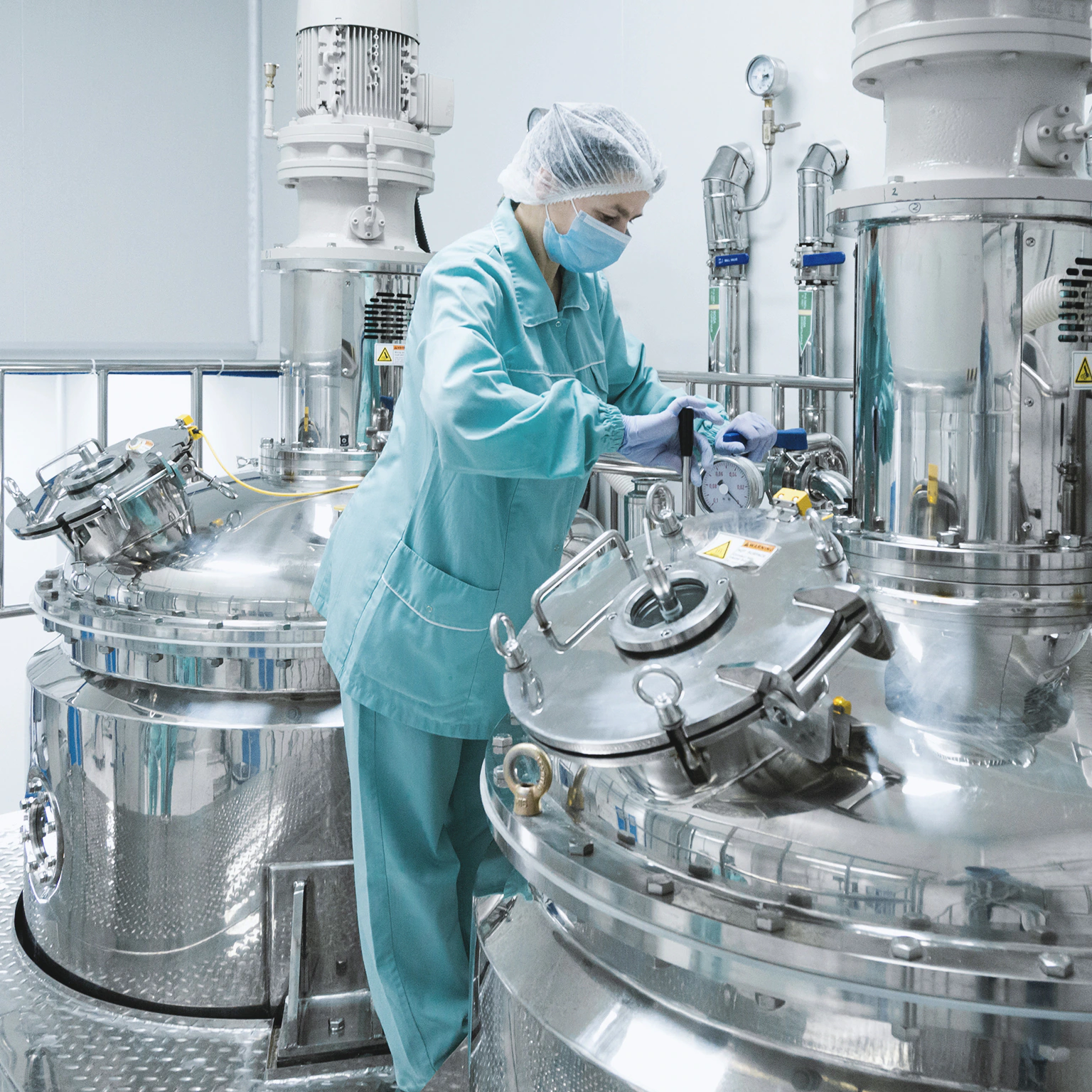 Technician operates pharmaceutical machinery in sterile lab environment, showing part of the supply chain of sarms in uk